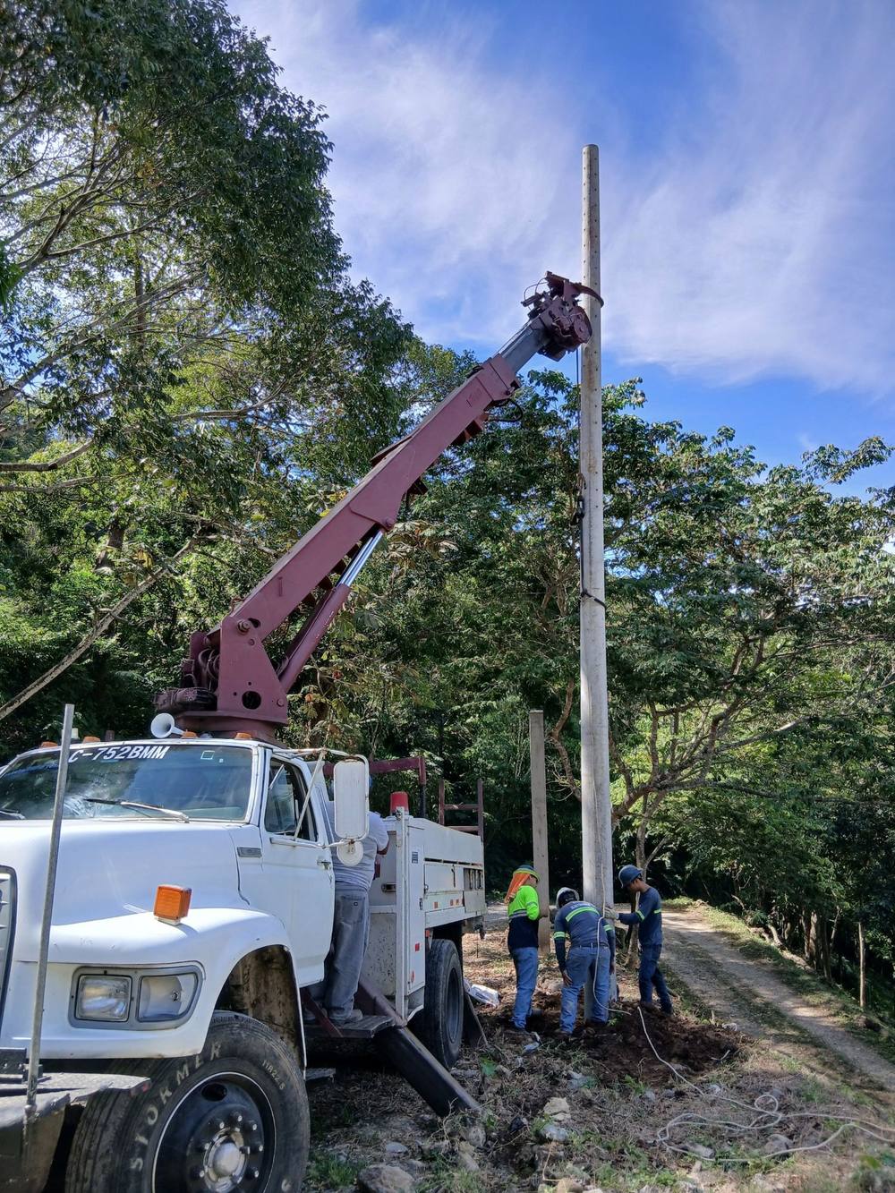 Camión grúa de EISA instalando un poste de media tensión